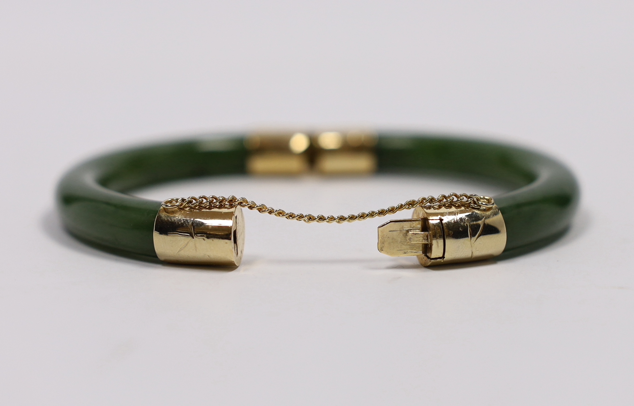 Am Eastern gilt metal mounted nephrite hinged bangle, 7.5cm